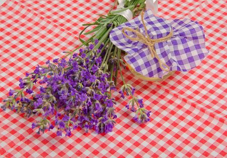 lavender and oil in bottle on checkered tableclothの写真素材