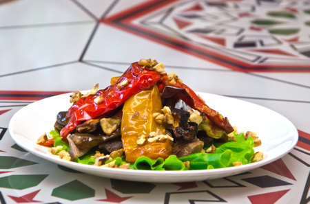 roasted meat under vegetables on plate on tableの写真素材