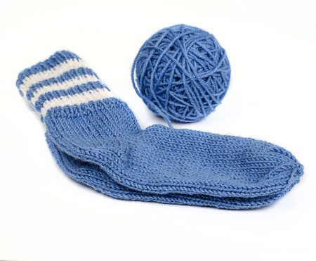 knitted socks from woolen thread and skein of thread on a white backgroundの写真素材
