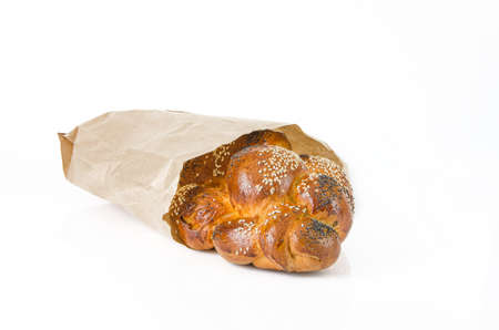 fresh wicker bun in paper package on white background