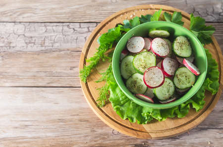 radish and cucumber salad  in bowl on wooden tableの写真素材