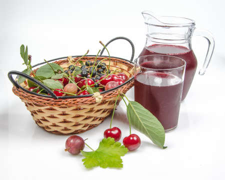 berries in basket and juice in a jug on a white backgroundの写真素材