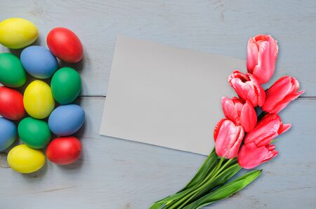Easter eggs different color and blank card with tulips