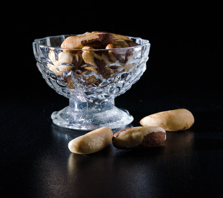 seeds of brazil nuts in glass bowl in darckの写真素材