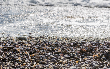 Sea stones by the sea, small pebbles in water