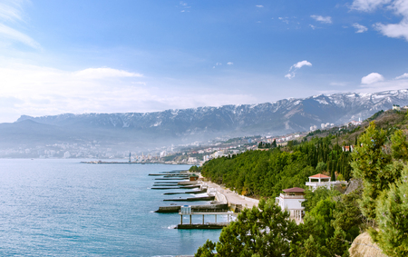city on the bay in the background of snowy mountainsの写真素材
