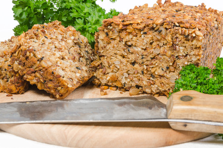 homemade grain bread with parsley on cutting board on white backgroundの写真素材