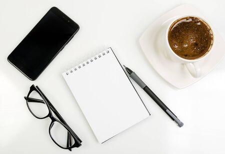 workplace with phone and glasses  and coffee on white backgroundの写真素材