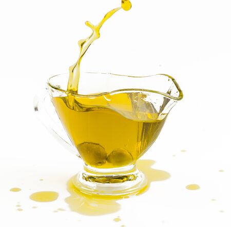 olive oil splash in gravy boat on white backgroundの写真素材
