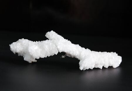 white crystals of salt on a black background in dark