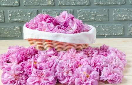 pink tea roses in basket and roses on tableの写真素材