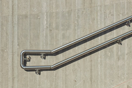 View of concrete wall with metal handrail railing.