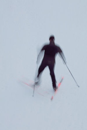 Intentional camera movement (ICM) image of cross-courtry skier going up a hill created by motion blur.の写真素材