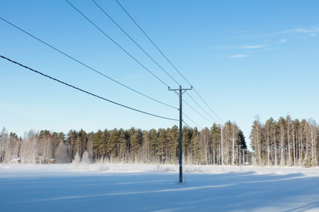 Power lines in clear winter weather with snow on the ground, Loppi, Finland.の写真素材