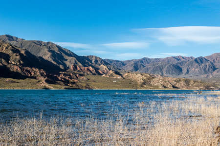 Wonderful Potrerillos Mountains in front of lake and clouds in the sunset.の写真素材