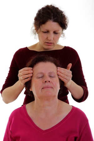 Woman giving a head massage to a senior woman の写真素材