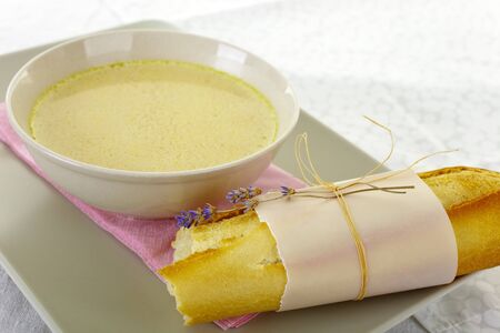 Weddings menu  yellow soup and fresh baguete decorated with lavender の写真素材