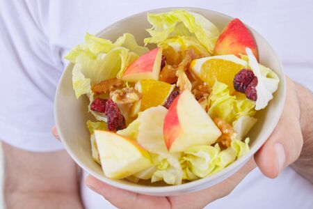 Male hands holding a fruit salad の写真素材