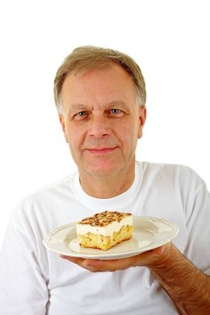 Portrait of mature man holding a piece of cakeの写真素材