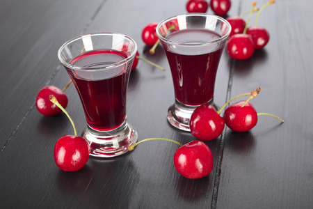 Cherry liqueur in a glass and fresh fruit.の写真素材