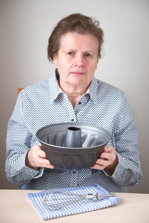 Senior woman holding a baking formの写真素材
