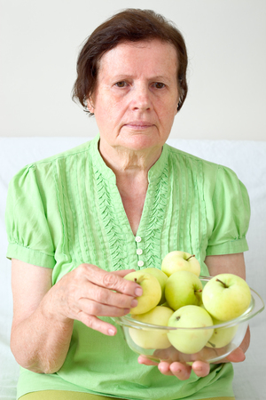 Senior woman with a green applesの写真素材
