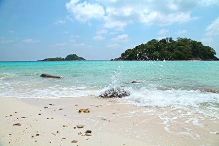 wave bubble foam on white sand beach with blue sky summer and island view in thailandの写真素材