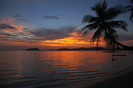 swing or cradle hang on the coconut tree beautiful sunset at koh Mak beach Trad Thailandの写真素材