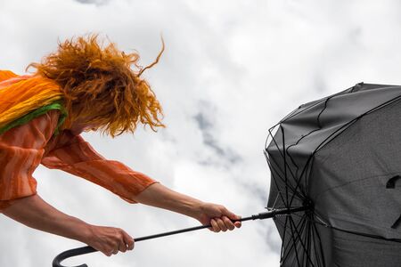 A woman tries to help her in a strong windの写真素材