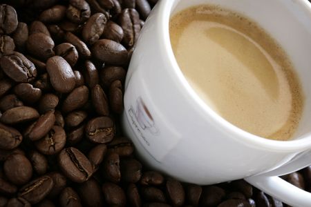 close-up of espresso cup with coffee beans around itの写真素材