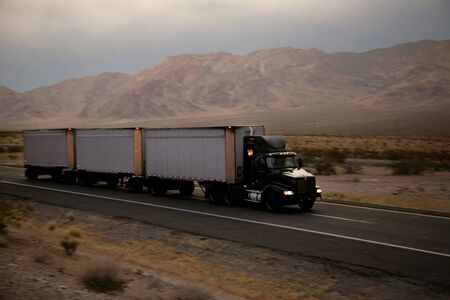 truck driving on a freeway at sunsetの写真素材