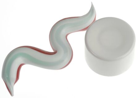 closeup of toothpaste with colored stripes on white background