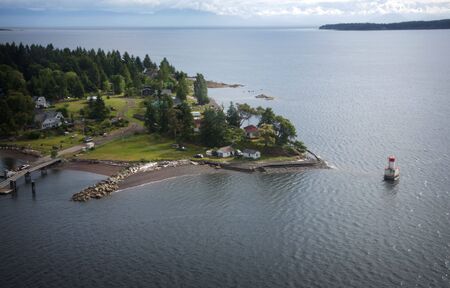 aerial view of an island with small lighthouse and housesの写真素材
