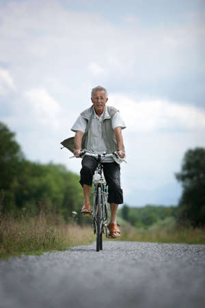 older man on his bicycle in the countrysideの写真素材