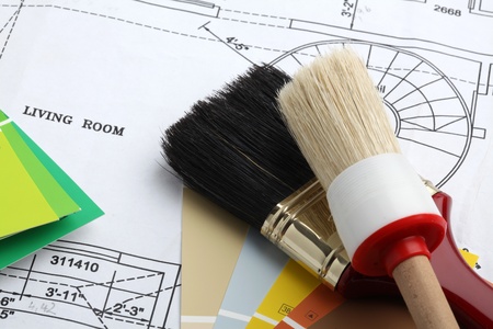 paintbrush and color samples on a blue print of a houseの写真素材