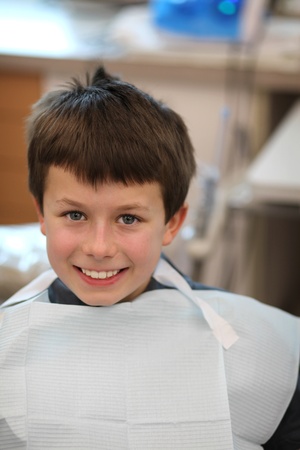 young boy in a dentist chair smilingの写真素材
