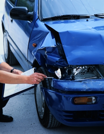 expert evaluating damage on a carの写真素材