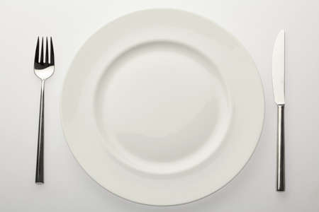 empty white plate with fork and knifeの写真素材