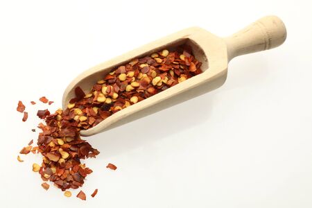 dried chilli on a wooden spoon over whiteの写真素材