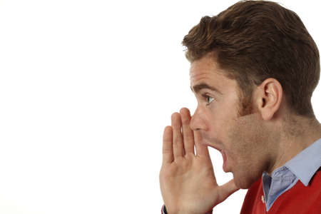 profile of a young man screaming with hand on his mouthの写真素材