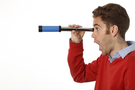 young man looking through a telescopeの写真素材