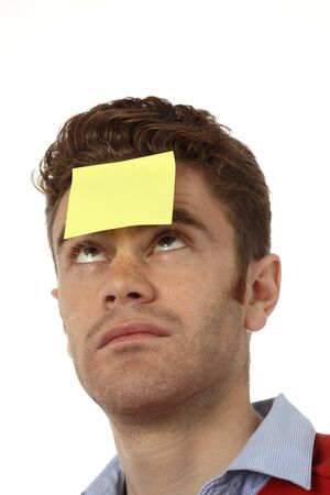 young man with emty post it on his foreheadの写真素材