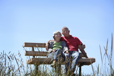 Happy old couple sitting on a benchの写真素材