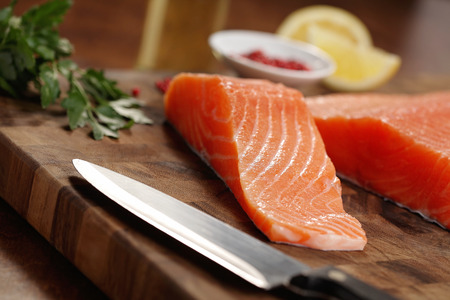 closeup of a salmon fillet on a cutting boardの写真素材