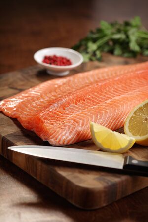 closeup of a salmon fillet on a cutting boardの写真素材