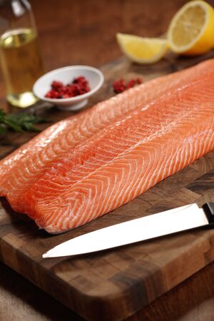 closeup of a salmon fillet on a cutting boardの写真素材