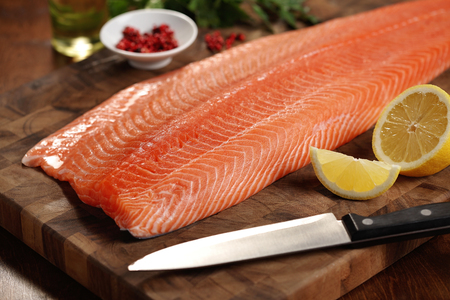 closeup of a salmon fillet on a cutting boardの写真素材