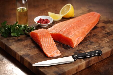 closeup of a salmon fillet on a cutting boardの写真素材