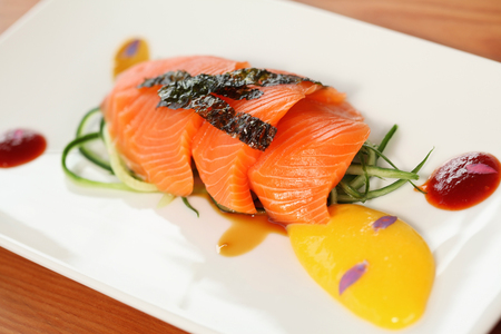 close up of salmon fillet decorated on a white plateの写真素材