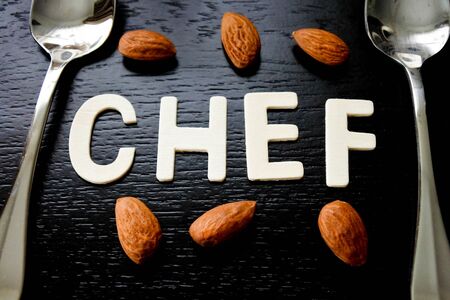 Chef, Close up the word arrangement from wood pieces alphabet and toasted almond on black background.の写真素材